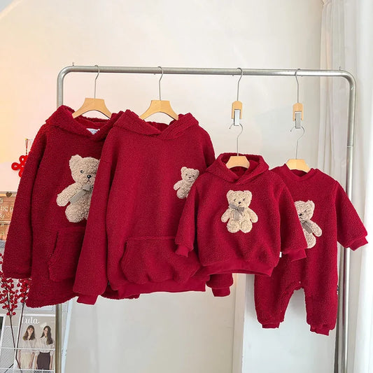 Matching family red hoodies with bear design for Christmas.